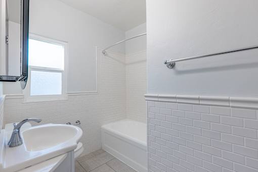 a bathroom with a sink and a tub and a window