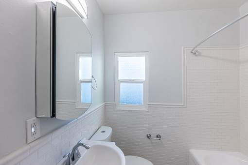 a bathroom with a sink and a mirror and a window