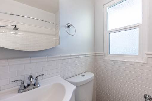 a bathroom with a sink and a toilet and a window