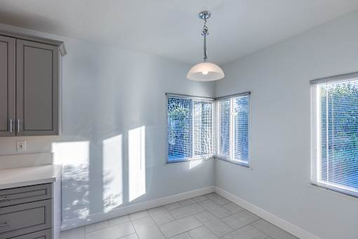an empty kitchen with white walls and a window
