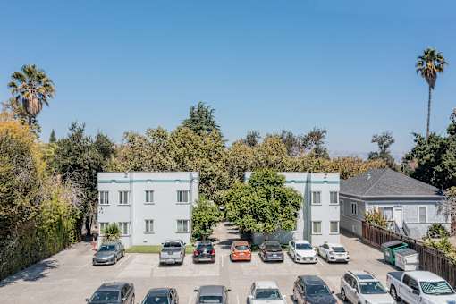 an aerial view of an apartment complex with cars parked in the parking lot