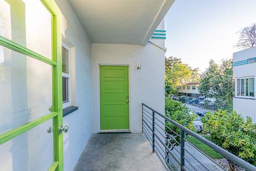 the entrance to a balcony with a green door