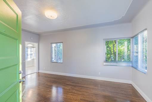 an empty room with a green door and a window