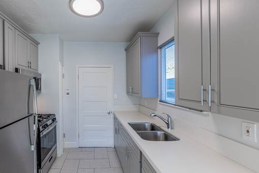 an empty kitchen with a sink and a refrigerator