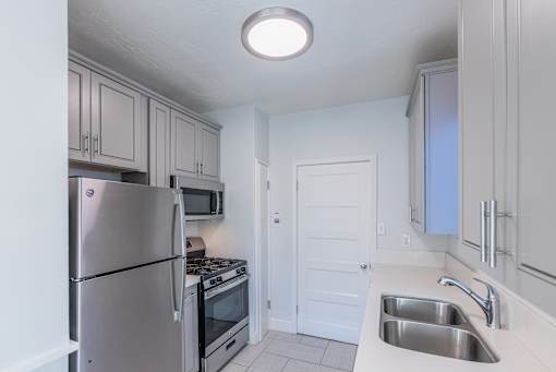 a kitchen with stainless steel appliances and white cabinets