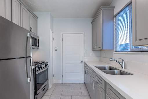 an empty kitchen with a sink and a refrigerator
