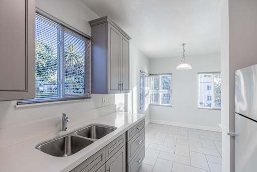an empty kitchen with a sink and a refrigerator