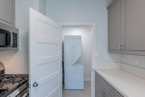 an empty kitchen with a refrigerator and a washer and dryer