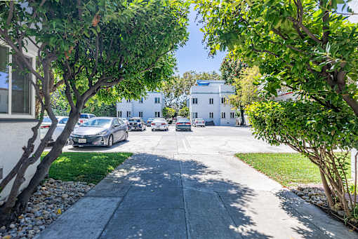 a view of a street with cars parked in front of a building