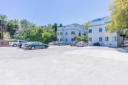 a parking lot with cars in front of a white building
