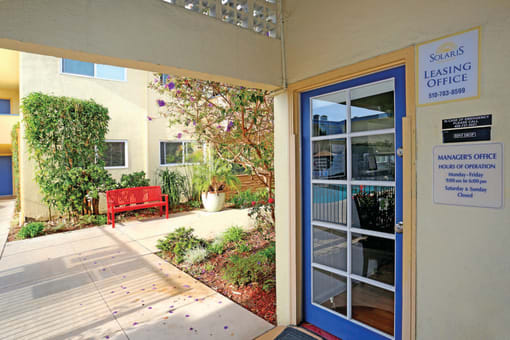 the entrance to the leasing office of a building with a blue door