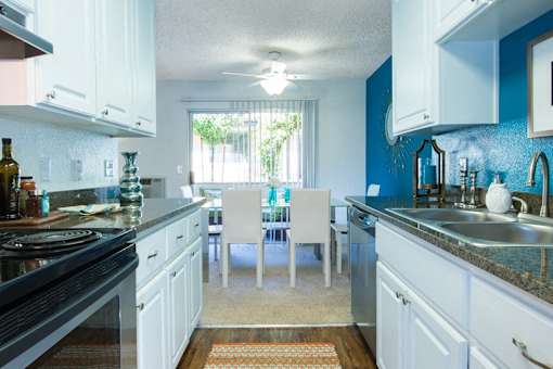 A kitchen with white cabinets and a black stove top oven.