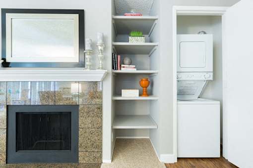 A modern living room with a fireplace and built in shelves.