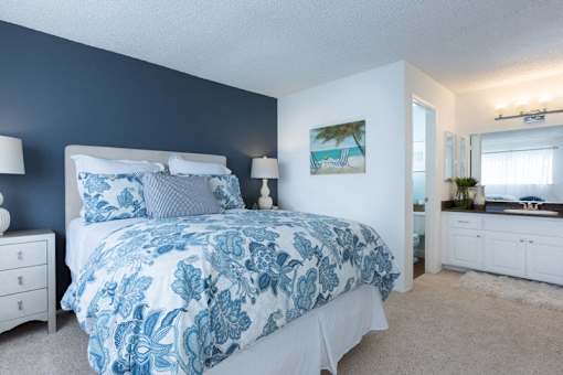 A bedroom with a large bed and a painting on the wall.