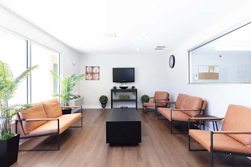 A living room with a brown sofa, a black coffee table, and a flat screen TV.