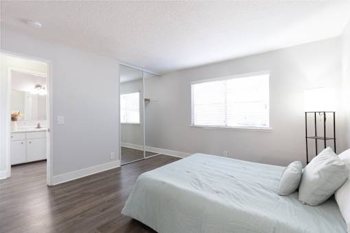 A bedroom with a bed, a dresser, and a mirror.