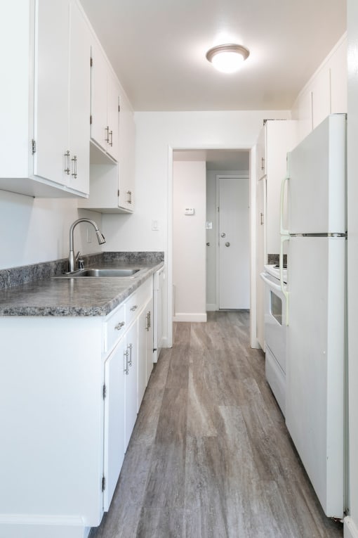 a kitchen with white cabinets and a white refrigerator