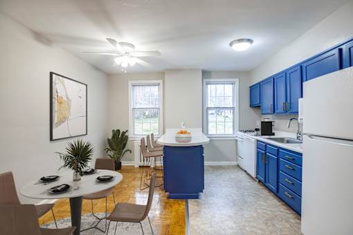 A kitchen with blue cabinets and a white refrigerator.