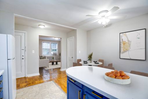 A kitchen with a white counter and blue cabinets.