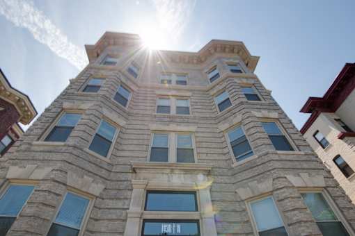 The sun is shining brightly on the side of a tall building.