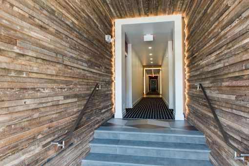 A long hallway with wooden walls and a light at the end.