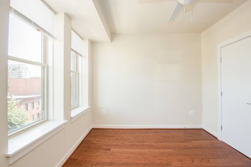 Empty room with white walls and wooden floor.