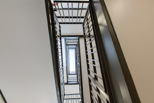 A staircase with a metal railing and a glass balustrade.