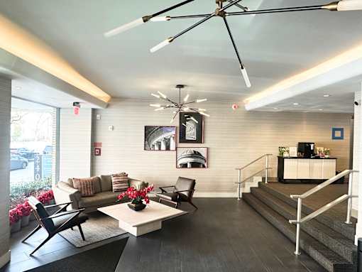 A modern living room with a black chair and a white coffee table.