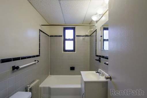 A white bathroom with a tub, toilet, and sink.