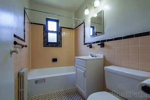 A bathroom with a white toilet, sink, and bathtub.