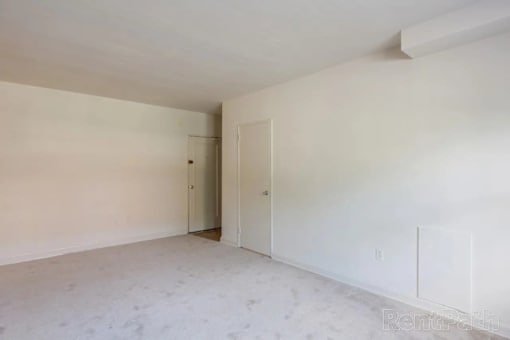 A white room with a door and a wall socket.