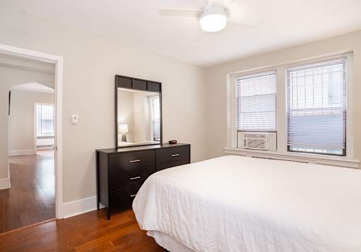 A bedroom with a bed, dresser, and mirror.