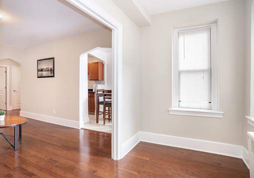 A room with a window and a dining table.