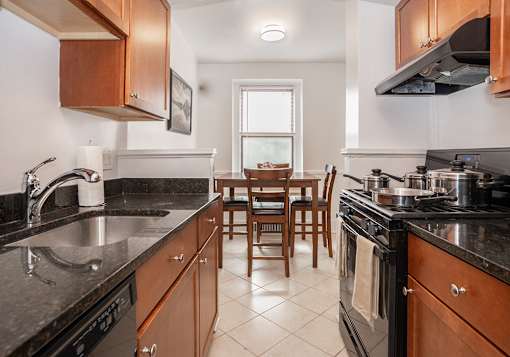 A kitchen with black countertops and wooden cabinets.
