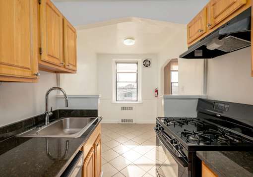 A kitchen with wooden cabinets and black countertops.