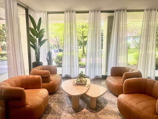 A room with orange chairs and a table with a plant on it. at Calvert House Apartments, Washington, DC 20008