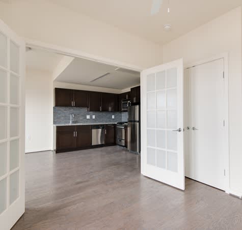 A kitchen with dark brown cabinets and a white door.