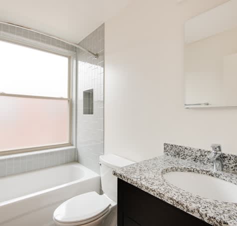 A white toilet sits next to a bathtub in a bathroom.