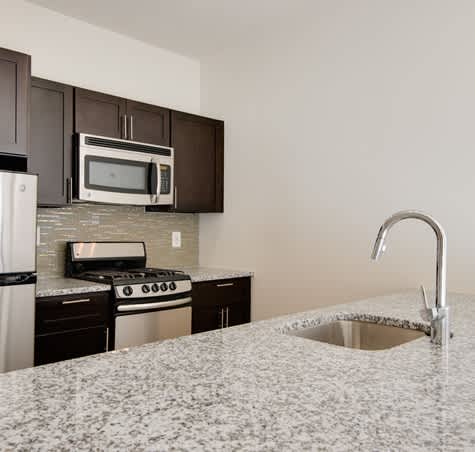 A kitchen with granite countertops and stainless steel appliances.