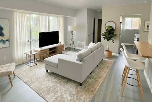 A living room with a white couch and a television.