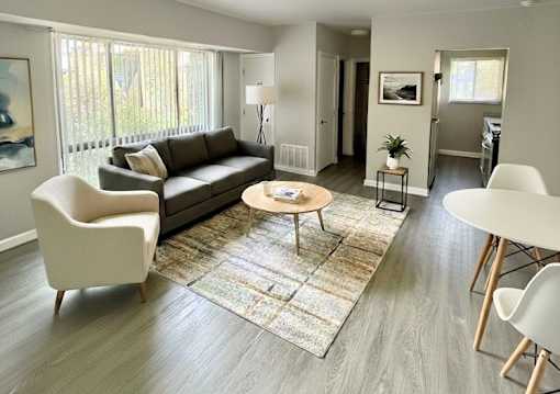 A living room with a couch, chairs, and a table.