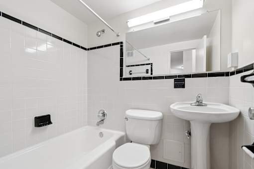 A white bathroom with a tub, toilet, and sink.