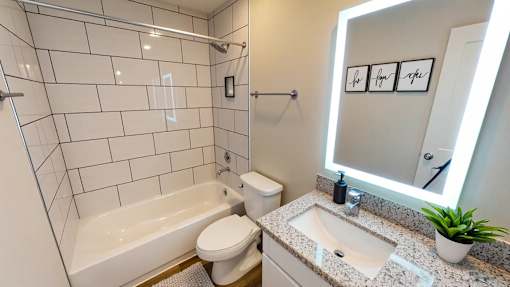 A white bathroom with a toilet, sink, and bathtub.
