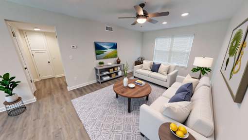 A living room with a white couch, a coffee table, and a painting on the wall.