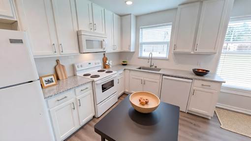 A kitchen with white cabinets and appliances.