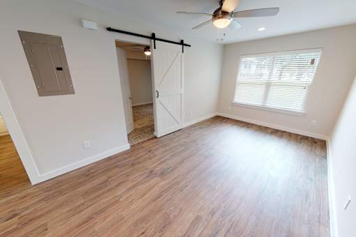 A room with a ceiling fan and a sliding door.