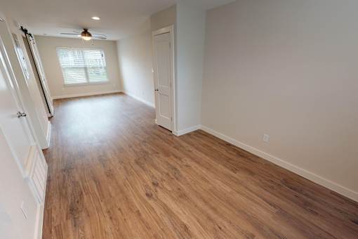 A room with wooden flooring and a ceiling fan.