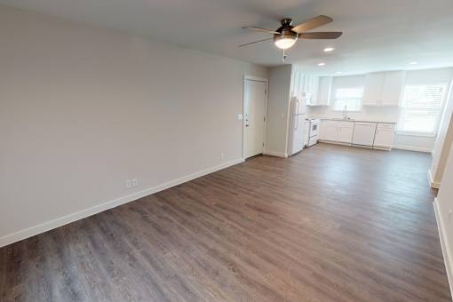 A room with a ceiling fan and wooden flooring.