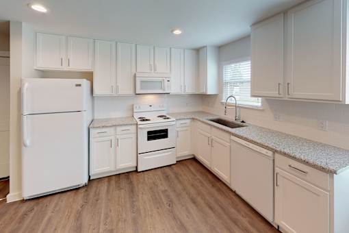 A kitchen with white appliances and cabinets.