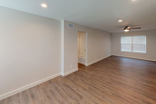A room with wooden flooring and a ceiling fan.
